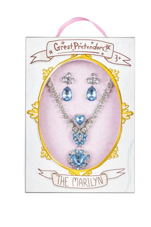 A 4-piece jewellery set by Great Pretenders, featuring blue and silver clip-on earrings, a heart-shaped ring, and a coordinating necklace, packaged in a pink box with a clear window displaying the items.