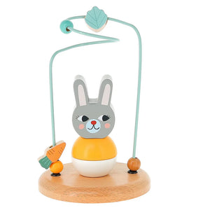 A wooden toy featuring a rabbit with a carrot, designed for young children, illustrated by Michelle Carlslund.