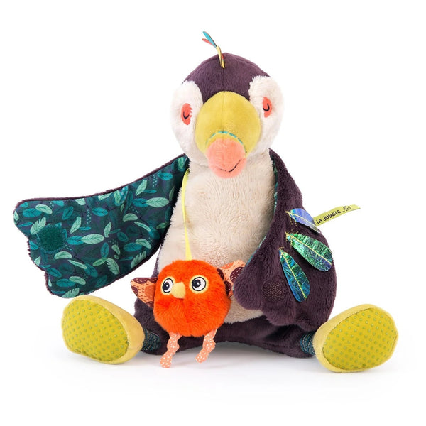 Stuffed penguin toy with a small orange creature on a white background