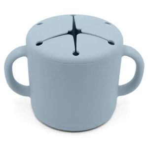 A blue silicone snack cup with double handles and a soft opening for snacks, designed for young children.