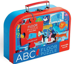 A colorful Crocodile Creek 24-piece floor puzzle in a red and blue suitcase with animal illustrations.