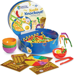 The image shows a fine motor skills game called 'Ramen Noodle Knockout' with various colorful pieces including noodles, veggies, and a spinner. The game is packaged in a blue box that serves as a storage and gameboard, and includes a set of instructions.
