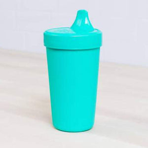 Turquoise sippy cup on a light gray surface with a white background