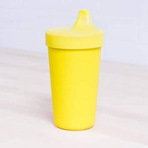 Yellow sippy cup on a light gray background