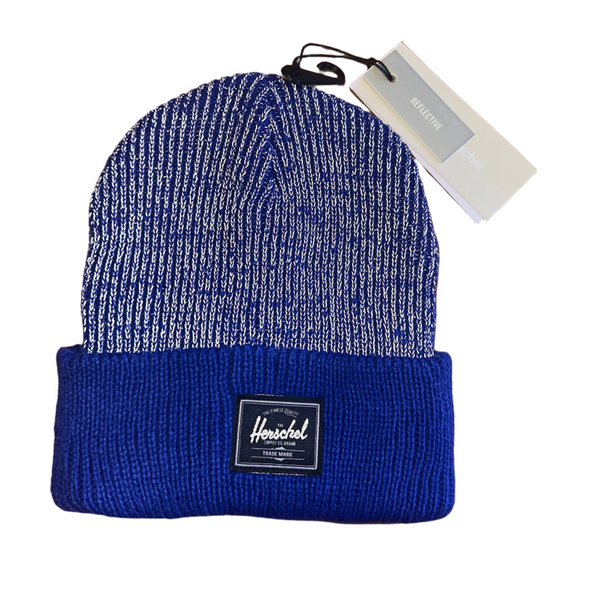 Blue knit beanie with a tag on a wooden surface