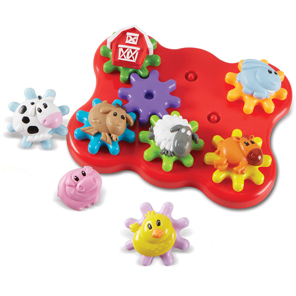 A colorful children's farm-themed peg puzzle toy on a white background. The red bone-shaped board has green pegs and attached farm animal pieces including a barn, dog, sheep, cow, pig, chicken, and sun.
