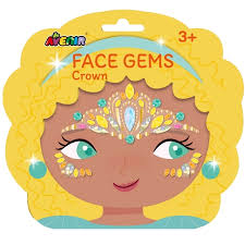 A packaged children's face gem sticker set shaped like a crown, with a cartoon face illustration and the text 'FACE GEMS Crown' and '3+'. The package is predominantly yellow and blue, showing decorative jewel stickers on the forehead and cheeks.