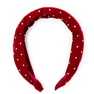 A red velvet headband with white sparkle accents.