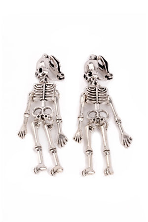 Skeletal dog-shaped earrings on a white background
