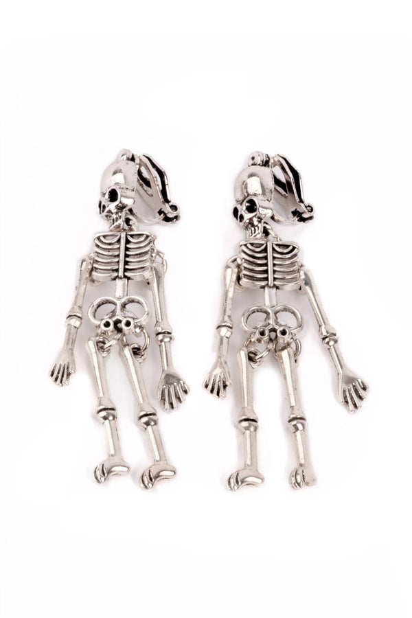 Skeletal dog-shaped earrings on a white background