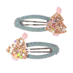 Three decorative hair clips with gemstones and pink pom-poms on a white background