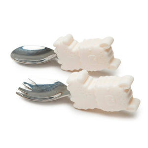 A toddler fork and spoon set with animal character designs on the handles, made of silver and white silicone.