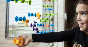 Child playing with colorful magnetic toys on a window