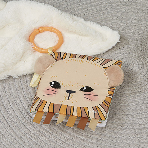  lion-shaped baby rattle with orange handle on a textured surface