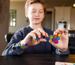 Child playing with colorful magnetic building blocks in a kitchen setting