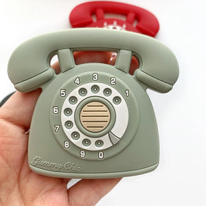 Green rotary phone-shaped object held in a hand with a white background