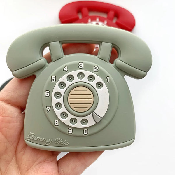 Green rotary phone-shaped object held in a hand with a white background