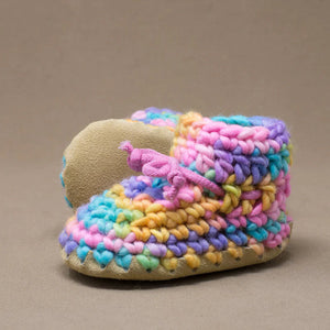 Colorful crocheted slippers on a brown background