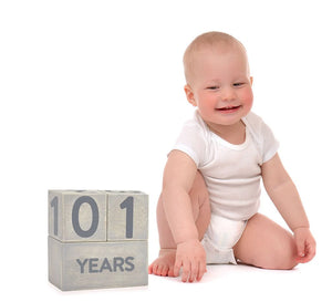Baby sitting next to a block set displaying '101' on a white background