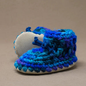 Blue and purple baby booties on a brown background