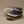 Pair of brown and white crocheted baby shoes on a beige background