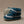 Pair of blue and white baby booties on a beige background