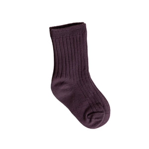 A single purple baby sock with a ribbed texture laid flat on a neutral background.