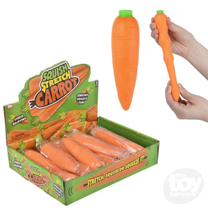 A box of Squish Stretch Carrots with a hand holding one of the stretchable carrot toys. The toy is orange in color and designed to stretch and squeeze.