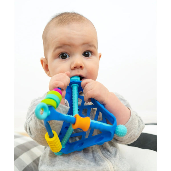 Baby holding a colorful teething toy with a white background