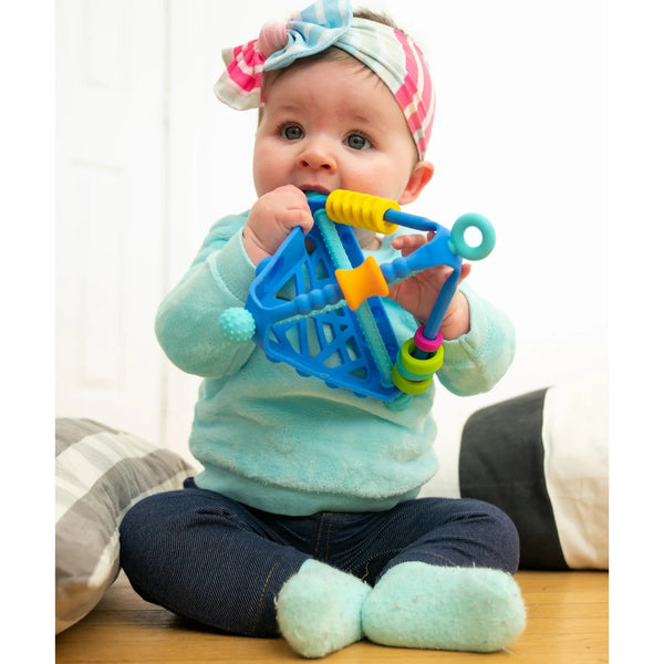 Baby holding a colorful toy with a white background
