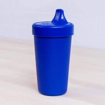 Blue sippy cup on a light beige surface with a white background